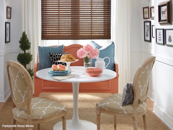 A rose colored bench in a dining room.